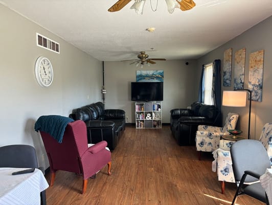 Cozy living room with black leather sofas and decorative chairs