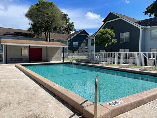 Swimming pool area with facility buildings in the background