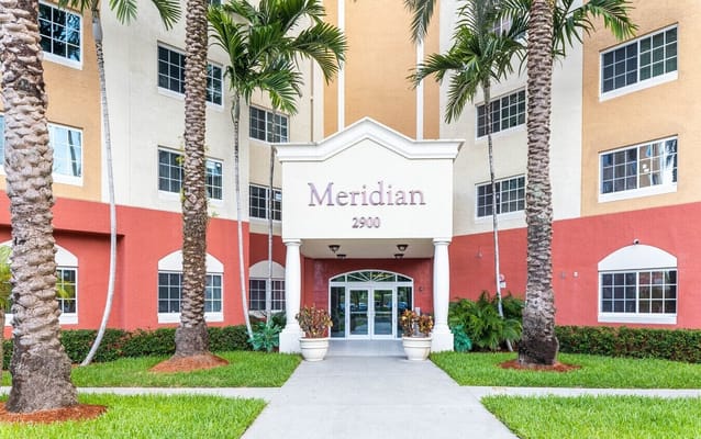 Exterior view of the Meridian facility entrance with palm trees