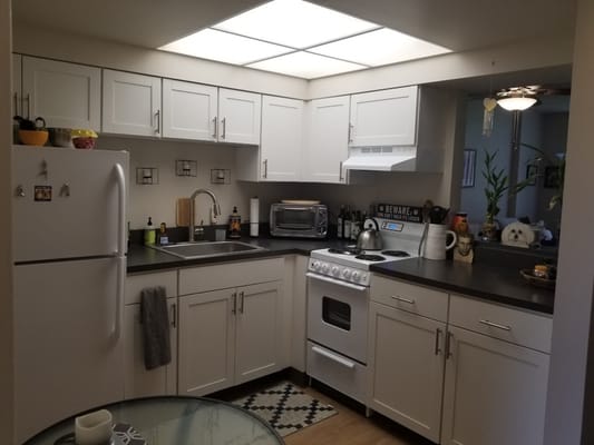 Compact kitchen with modern appliances and black countertops