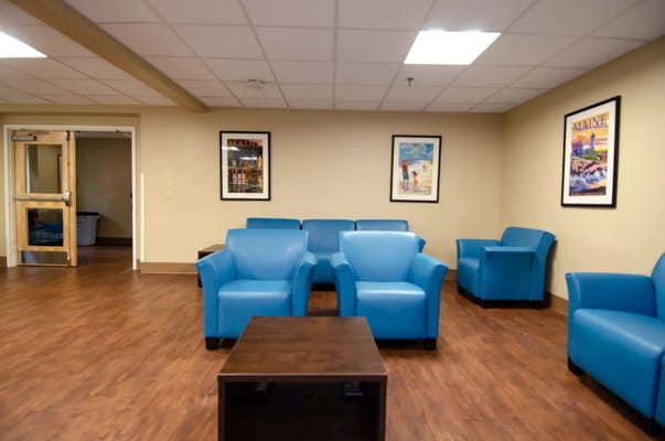 Interior common area with blue chairs and artwork