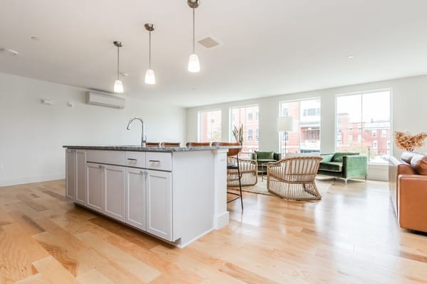 Modern living room with green chairs and large windows