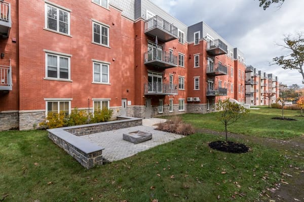 Exterior of Stevens Square at Baxter Woods featuring red brick buildings and landscaped area.