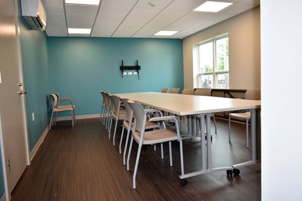 A meeting room with tables and chairs