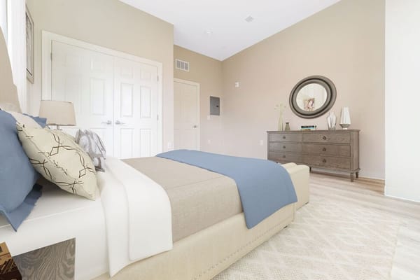 A well-furnished resident room with a bed and dresser