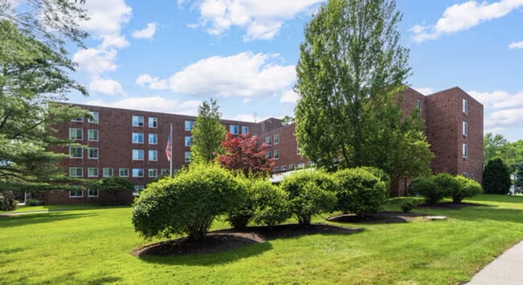 Exterior view of Bet Shalom Senior Apartments surrounded by greenery