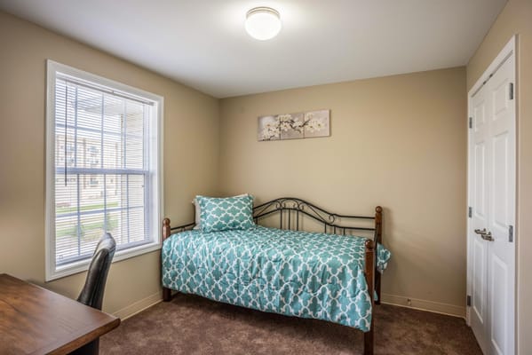 Cozy private resident room with a bed and desk