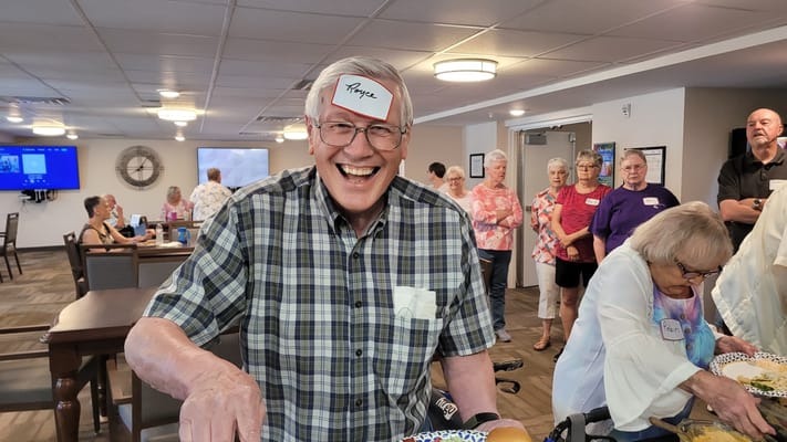 Resident smiling at an activity with a name tag