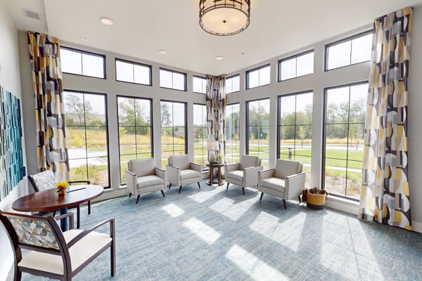 Bright common area with large windows and seating