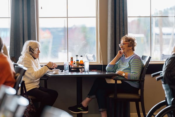 Two women chatting at a table in the dining area