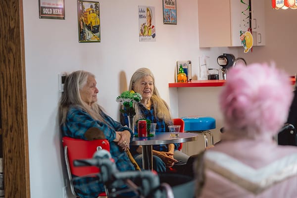Two residents chatting in a common area with bright decor