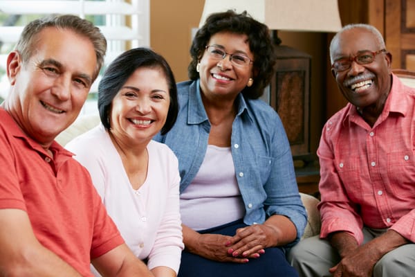 Group of smiling senior residents in a cozy common area