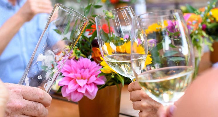 Residents raising glasses at a celebration with flowers