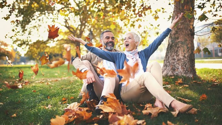 Two residents enjoying autumn leaves outdoors