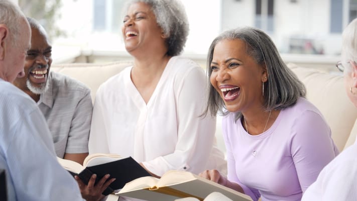 Group of seniors laughing and reading together