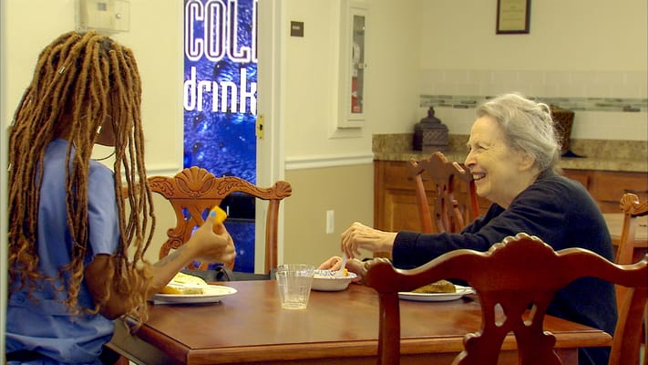 A staff member and a resident enjoying a meal together