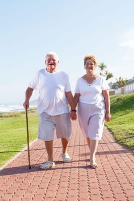 Senior couple walking hand-in-hand on a path