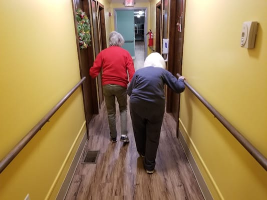 Two residents walking in a brightly colored hallway