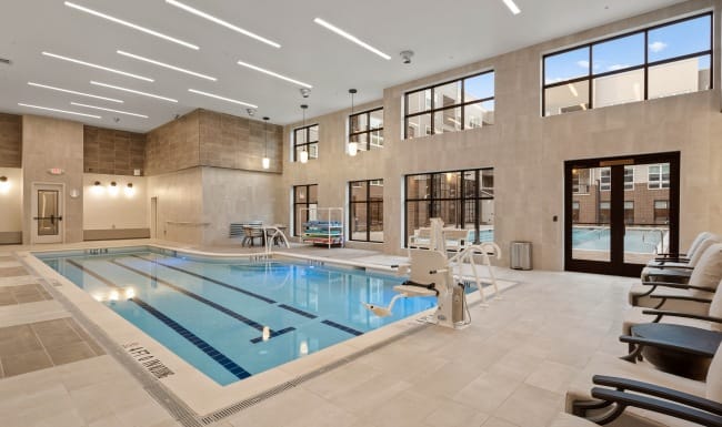 Indoor swimming pool area with seating and large windows