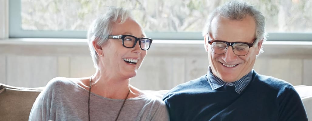 Two smiling seniors enjoying time together indoors