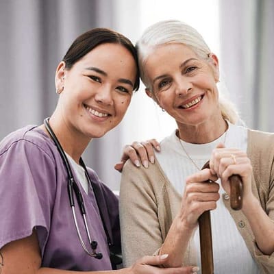 Nurse and resident smiling together in an interior setting