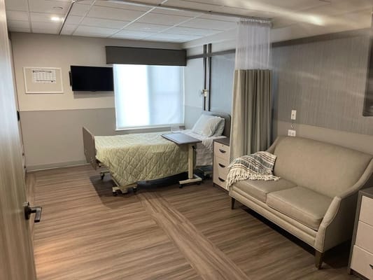 A private resident room with a bed and seating area