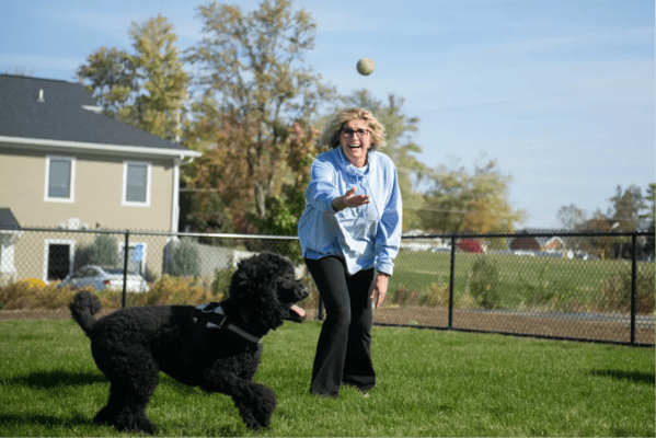 Resident playing fetch with a dog in the yard