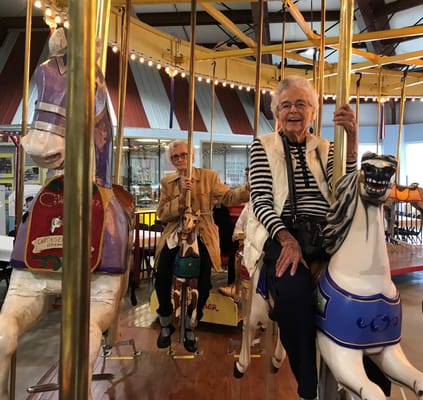 Residents enjoying a carousel ride in a decorated indoor space