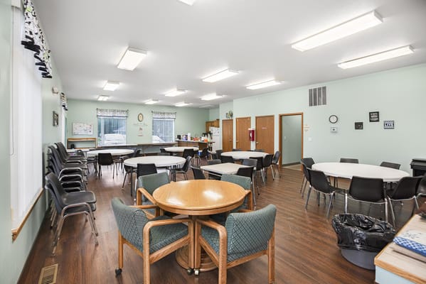 Interior view of a bright common area with tables and chairs
