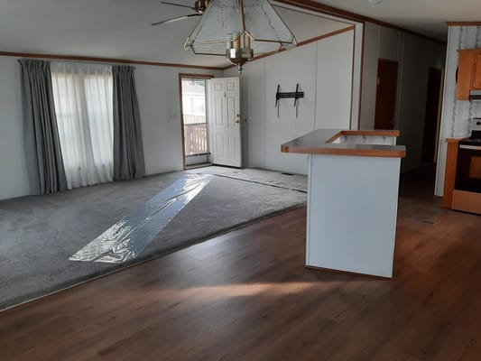 Interior view of a living space with carpet and kitchen
