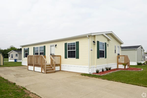 Exterior view of a mobile home with a ramp and front entry