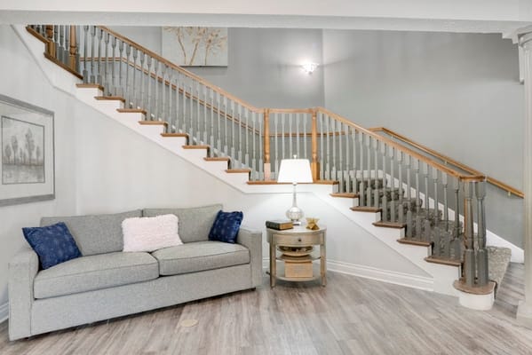 Living room featuring a gray couch and staircase