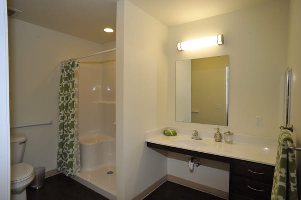 A private bathroom featuring a shower, sink, and storage at Central Park Place.