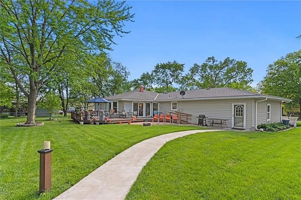 A spacious backyard with seating and a pathway at Comfort Living senior facility.