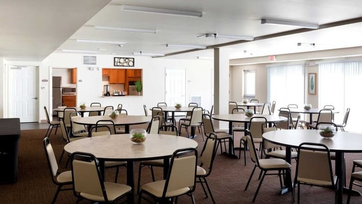 A spacious dining area with round tables and chairs, designed for communal meals.