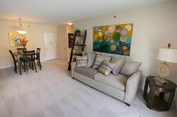 Cozy living area with a sofa, dining table, and colorful artwork