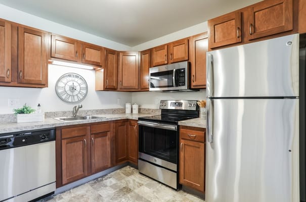 A modern kitchen with wood cabinets and stainless steel appliances.