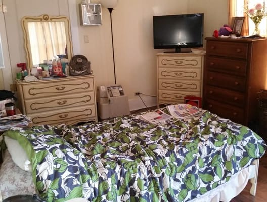 Cozy bedroom with floral bedding and a TV.
