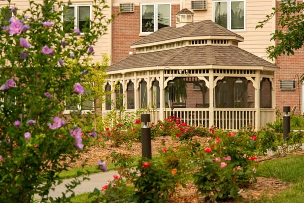 A gazebo in a garden filled with colorful flowers.