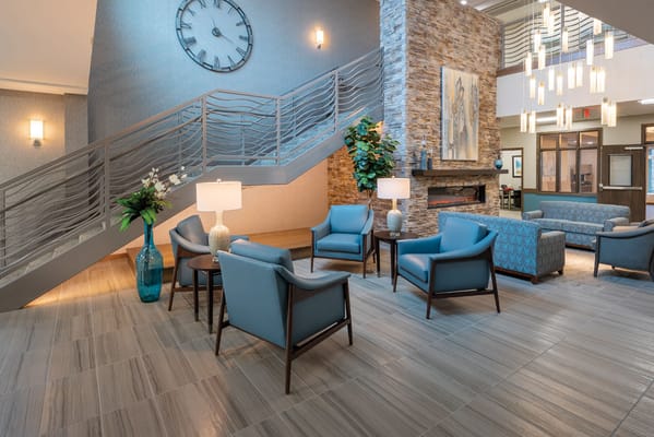 Contemporary lounge area with seating and a stone fireplace