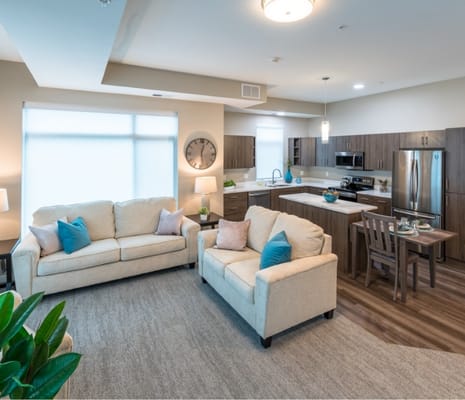 Modern living room with beige sofas and kitchen