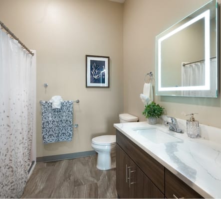 Bright and modern bathroom with a shower, sink, and decorative towel