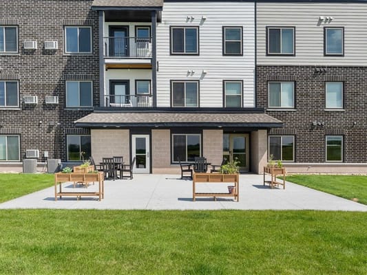 Exterior view of Vive Senior Apartments with outdoor seating