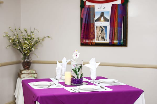 Elegant dining table with purple tablecloth and floral centerpiece