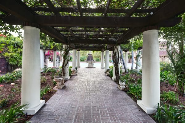 A landscaped pathway lined with columns and greenery