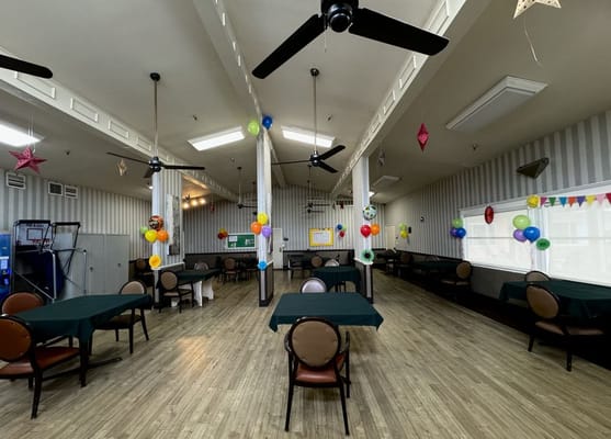 Empty dining room with green tables and colorful decorations.