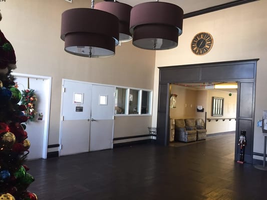 Spacious lobby with two hanging lamps and holiday decorations.