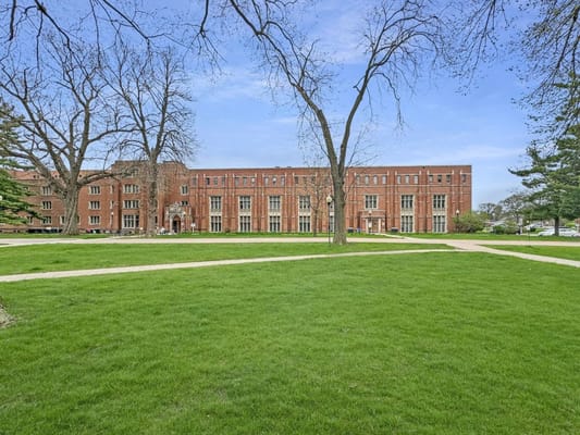 Red-brick building exterior surrounded by green lawn