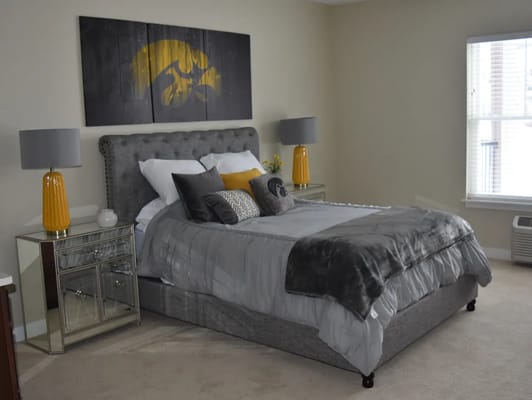 Stylish bedroom with a gray bed, decorative pillows, and a nightstand