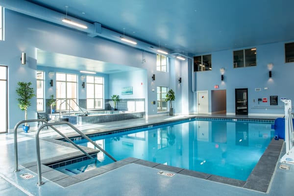 Indoor swimming pool area with blue walls and natural light